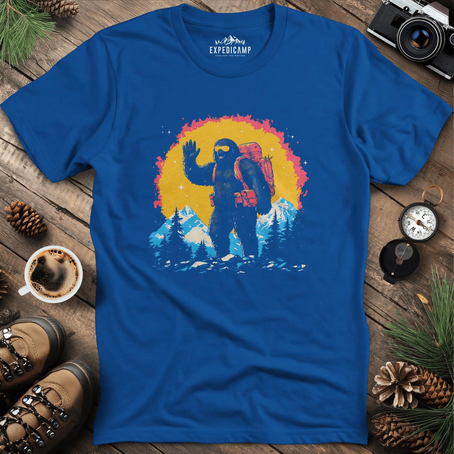 Bigfoot Waving T-Shirt – Friendly Sasquatch in the Mountains – Royal – Outdoor apparel for travel, hiking, camping, and nature lovers – ExpediCamp