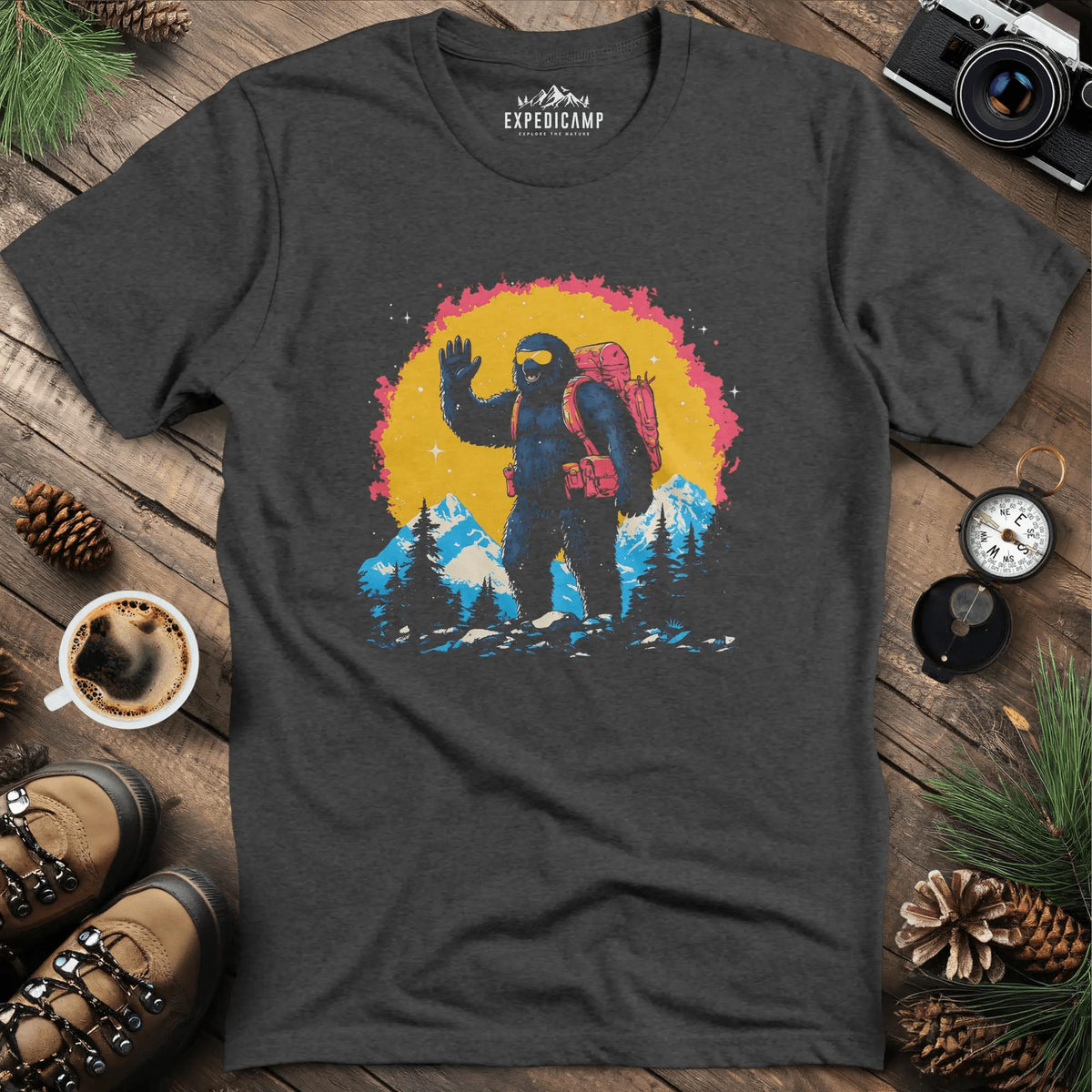 Bigfoot Waving T-Shirt – Friendly Sasquatch in the Mountains – Dark Heather – Outdoor apparel for travel, hiking, camping, and nature lovers – ExpediCamp