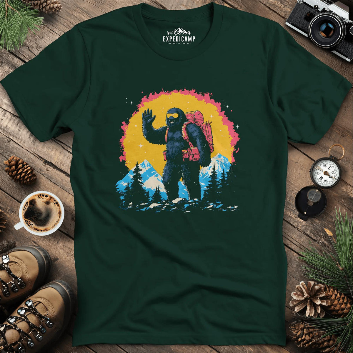 Bigfoot Waving T-Shirt – Friendly Sasquatch in the Mountains – Forest Green – Outdoor apparel for travel, hiking, camping, and nature lovers – ExpediCamp