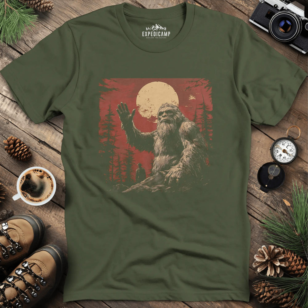 Bigfoot Waving T-Shirt – Friendly Sasquatch Under the Moon – Military Green – Outdoor apparel for travel, hiking, camping, and nature lovers – ExpediCamp